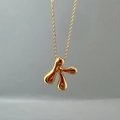 Close-up of golden letter K pendant necklace with polished irregular fluid metal design - Letter K Single Pendant