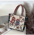 Detail of canvas tote bag featuring ethnic owl embroidery and geometric woven straps - Beige Owl Green Leaf