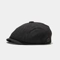 Detail of dark grey newsboy cap with textured twill fabric and round fashion patch - Black