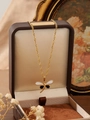 Detailed close-up of 18K gold dragonfly pendant with black and white enamel wings - Black and White Butterfly