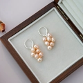 Silver grape cluster earrings with natural pink pearls on a wooden jewelry display box - Natural Orange-Pink