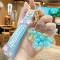 Blue liquid flower keychain with gold beads and Happy Day silicone strap charm - Pearl Sakura - Blue