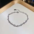 Macro view of silver bracelet with marquise and square cut zircons and lobster clasp - White