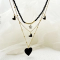 Detail of triple-layer necklace with black beads, gold chains, heart and star pendants - Black Heart Star Necklace / Black