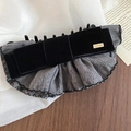Macro detail of fabric bow hair claw with velvet bow and gold metal LOVEDAYS tag - Twist Clip - Black and Grey
