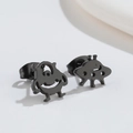 Close-up of black asymmetrical alien studs featuring a cute monster and UFO design - One-Eyed Monster / Black