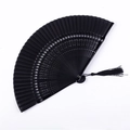 Détail macro de l'éventail pliable noir avec motifs ajourés et pompon élégant en soie - Face Satinée Noire Ajourée Flocon de Neige