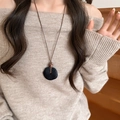 Collier vintage avec pendentif rond en bois et résine noire sur un pull beige élégant - 51# Collier-Noir-Moucheté