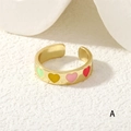 Detail of colorful enamel heart patterns on a gold adjustable open band ring - Multicolor Hearts (RG0446-A)