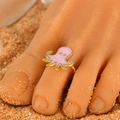 Pink octopus adjustable toe ring in gold finish on a sunny beach sand background - Pink Octopus (2544)