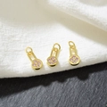 Macro detail of three gold flower pendants with pink cubic zirconia on a dual texture base - Pink Zirconia - Gold