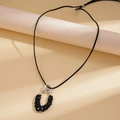 Detalle de anillo metálico plateado con tejido de cordón negro en collar de terciopelo - Negro