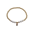 Close-up of golden beaded bracelet with white pearls and zircon encrusted letter B charm - Letter B
