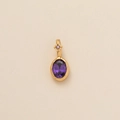 Close-up of golden birthstone pendant with purple oval zircon and diamond decoration - Oval February (Purple Zirconia)
