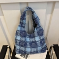 Blue denim patchwork hobo bag with frayed fringe edges on a black leather chair - Checkered Blue