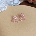 Macro-opname van drie roze hars kersenbloesem oorbellen op bruin papier achtergrond - 925 zilveren naald / Roze