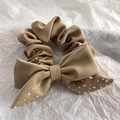 Close-up of beige gold satin scrunchie with a sparkling rhinestone bow detail - Khaki