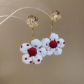 Detail von Blumenohrringen mit goldenen Blättern und roten Punkten auf Stoff mit Perlen - Goldene Basis Weiß Rot Gepunktetes Blumenmuster