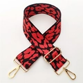 Close-up of a wide leopard print bag strap with red and black pattern and gold hooks - Red