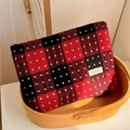 Dettaglio del beauty case in lana scozzese rosso e nero con pois bianchi nel cesto - Rosso Grande