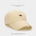 Detailed close-up of cream cotton baseball cap featuring embroidered polar bear motif - Beige