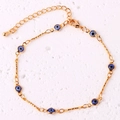 Detailed shot of a gold-plated evil eye link bracelet with blue charms and lobster clasp - Royal Blue Bracelet