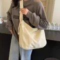 Large beige canvas tote bag with wide shoulder strap and front utility pocket for women - Off White