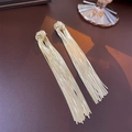 Detail of golden tassel earrings with knot design and sparkling metallic finish - Knotted Tassel Style / Gold