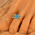 Adjustable golden toe ring with blue starfish design on sandy beach background - Blue Starfish (4723)