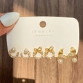 Three pairs of gold pearl earring sets including bow and fishtail designs on jewelry card - 52 Light KC Gold (10475)