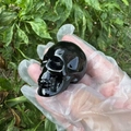 Black natural gemstone crystal skull held in hand, 5cm polished carving - Obsidian