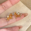 Golden unicorn stud earrings with orange zircon and clear crystals held by fingers - Unicorn Stud Earrings - 925 Silver Pin (WE5516-1)