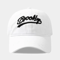 Gros plan de la broderie Brooklyn noire sur une casquette en coton lavé blanc - Réglable / Blanc