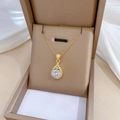 Gros plan d'un pendentif goutte d'or avec cristaux scintillants dans un écrin - Pendentif Goutte d'Eau Blanc (E412)