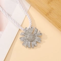 Primer plano de un sujetador de cortina de margarita plateada con cuerda blanca en madera - Accesorio Colgante de Margarita Plateada (4867)