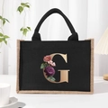 Black canvas tote bag featuring floral gold letter G print with comfortable handles - Bronze Floral Letter G