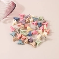 Detailed view of mini matte hair claws in assorted pastel colors stacked on a beige surface - Hanger Style / Bulk Packaging / Macaron Series