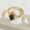 Golden crown ring featuring a black heart-shaped zircon on a white textured background - Crown Heart Black (JZ0238)