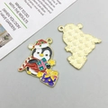 Detail of penguin enamel pendant with Christmas hat and gift, featuring golden metallic back - Christmas Gift Penguin (28x29mm)