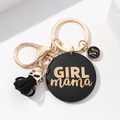 Dettaglio del ciondolo nero GIRL mama con scritte dorate e nappa nera sul portachiavi - Nero