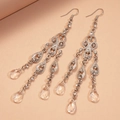 Eleganti orecchini a goccia con nappine argentate, strass e dettagli in vetro su sfondo tenue - Argento