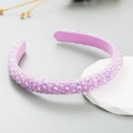 Detalle de diamantes morados en diadema fina de tela con acabado elegante de cristal - Morado