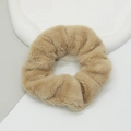 Macro detail of plush faux rabbit fur scrunchie in khaki on a geometric white tray - Khaki