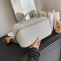 Close-up of a silver rectangular cosmetic bag with woven texture and a top handle - Silver