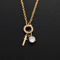 Collier en acier inoxydable finition or 14 carats avec breloques épée et cristal - Lettre T