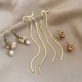 Set di 3 paia di orecchini dorati con perle e cristalli su un lussuoso tessuto di seta - Set di 3 paia / Ago d'argento-Oro-Caffè-Verde