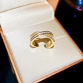 Macro di un anello incrociato placcato oro con pavé di zirconi in una scatola regalo - Stile Pavé Incrociato / Oro (Placcato Oro)