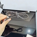 Close-up of elegant dark rhinestone bow hair clip with silver metal accents - Mineral Gray Rhinestone Style