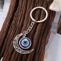 Silver evil eye moon keychain featuring ornate filigree and blue glass resin eye pendant - 4 Silver Moon Eye