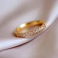 Minimalistische gouden titanium ring met halve cirkel kristallen op roze zijden stof - US 6 / Goud
